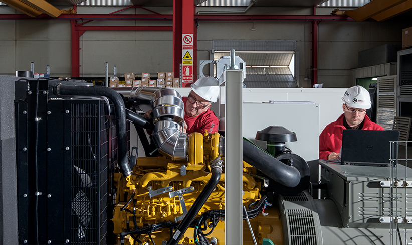 Technicians working on the maintenance and inspection of a generator in an industrial plant.