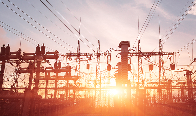 Power plant backlit against the sunset glow.
