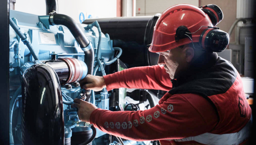 Technician performing maintenance on an industrial generator set.