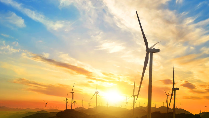 Wind farm at sunset, symbolizing the energy transition and sustainability in line with European Taxonomy standards.