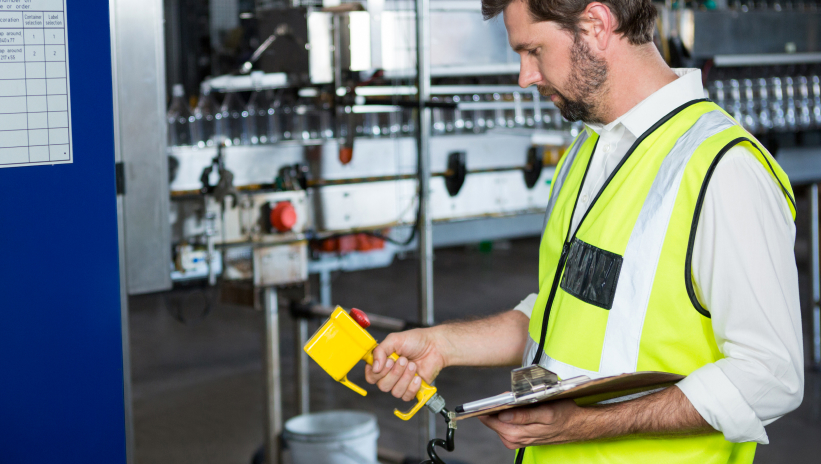 Technician inspecting industrial machinery and recording consumption.