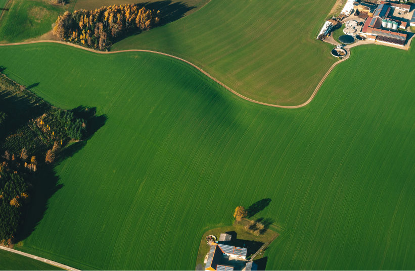 Aerial view of a rural area with wide fields and scattered buildings.